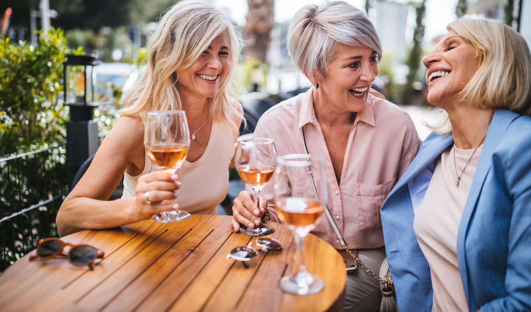 NOBLESVILLE'S PREMIER 55+ LUXURY COMMUNITY three women drinking wine outdoors